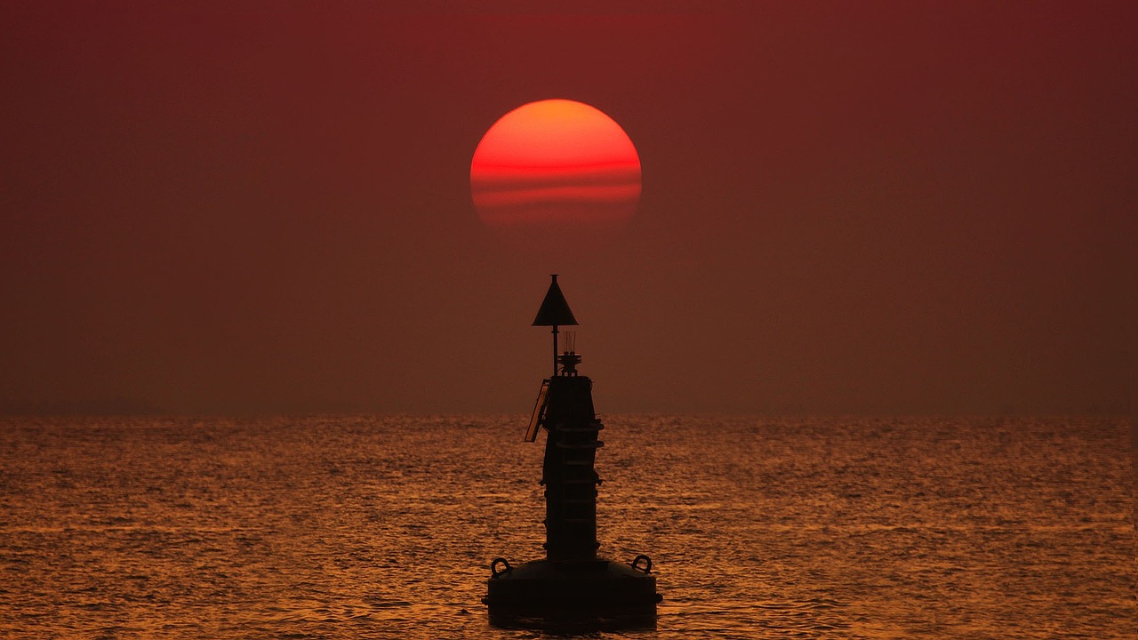 Moored buoy silhouetted at sunset