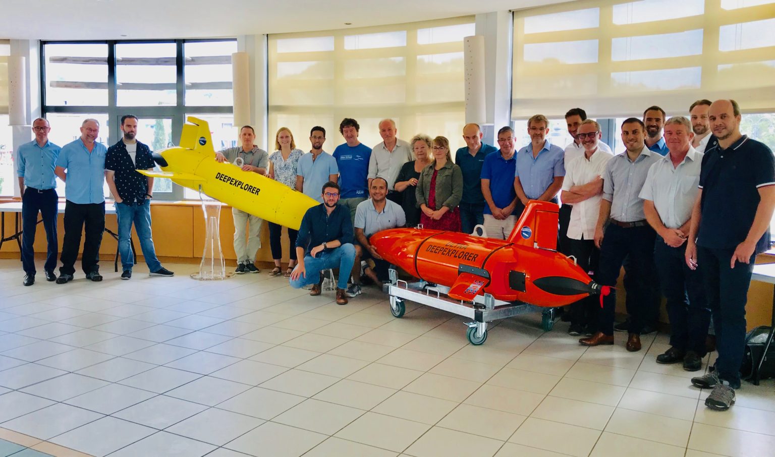 BRIDGES project partners standing behind the yellow Deep and red UltraDeep glider prototypes