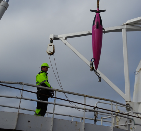 Crew member deploying a Seaglider from a ship's crane