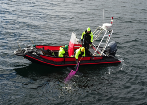 Crew in a small boat recovering a Seaglider from the sea